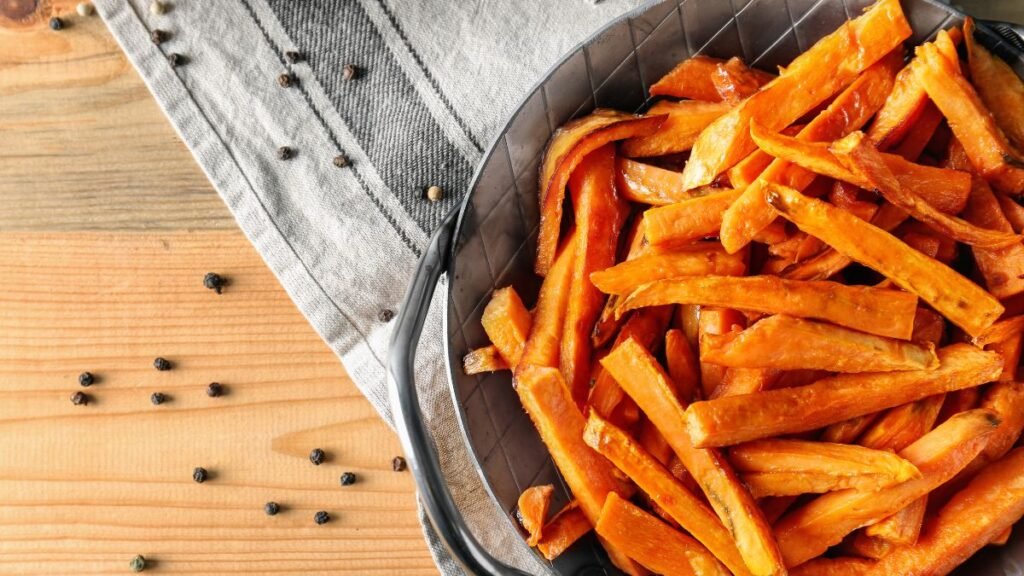 Pan with Sweet Potato Fries and Peppercorns on Wooden Table